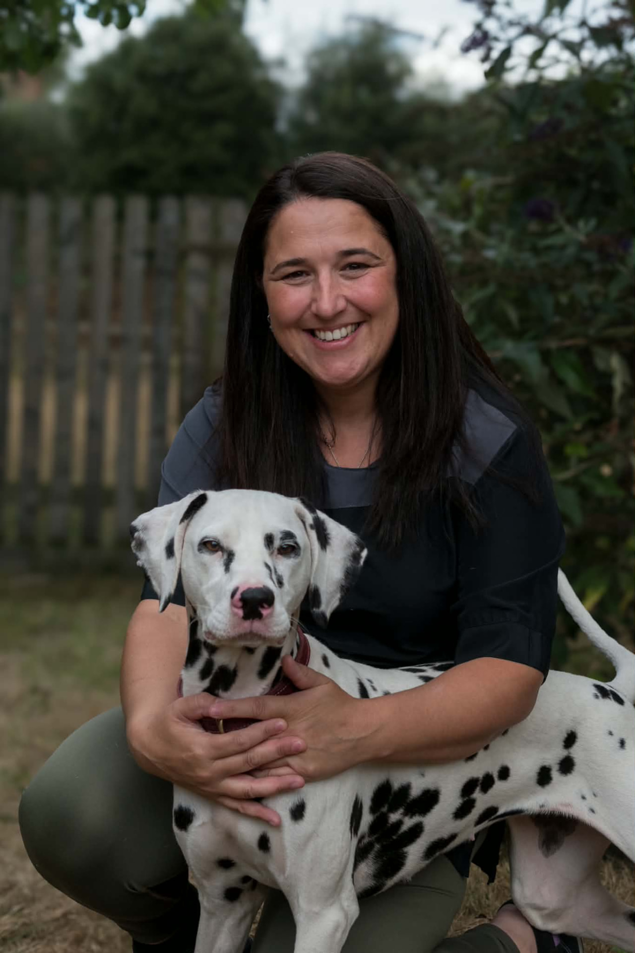 Jess with a Dalmatian dog in a garden setting